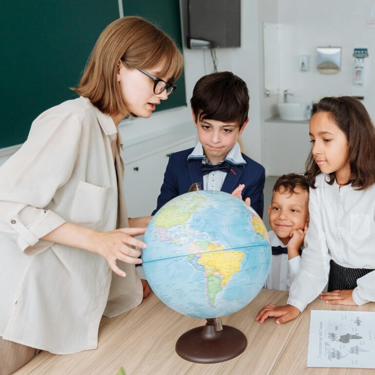A teacher and three students engaged in a geography lesson, examining a globe in a classroom setting.